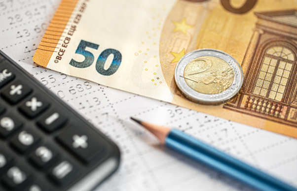 Alternativní text: 50-eurová bankovka, 2-eurová mince, kalkulačka a tužka na finančním dokumentu.