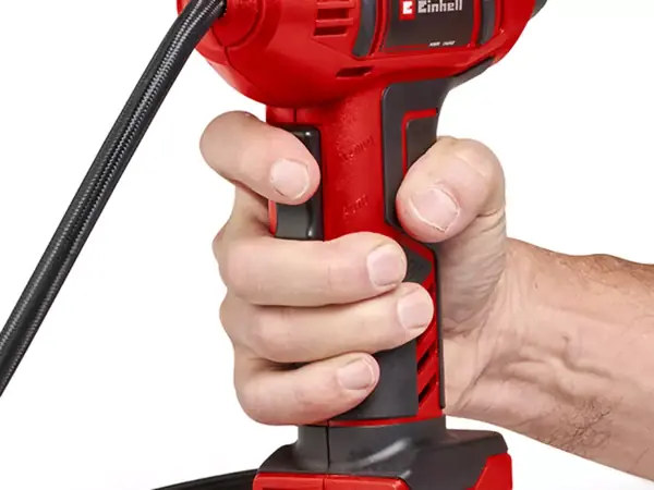 Ruka drží madlo akumulátorového autokompresoru Einhell CE-CC 18 Li-Solo při huštění.