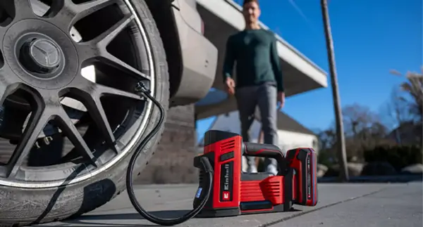 Aku kompresor na auto Einhell CE-CC 18/23 D Li-Solo je připojen k pneumatice auta; používá se automatická funkce.