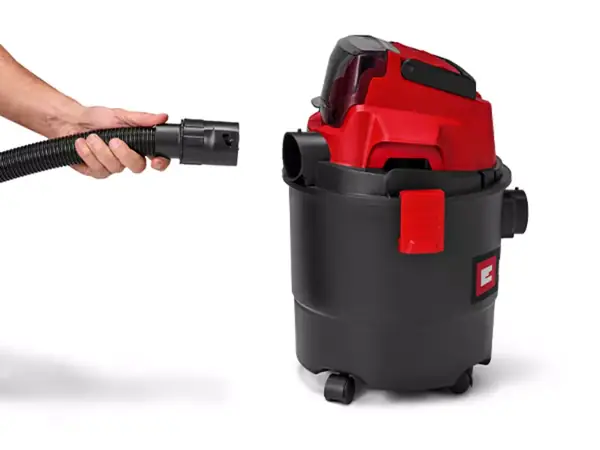 Eine Hand steckt den Saugschlauch in den Blasanschluss am Saugergehäuse.