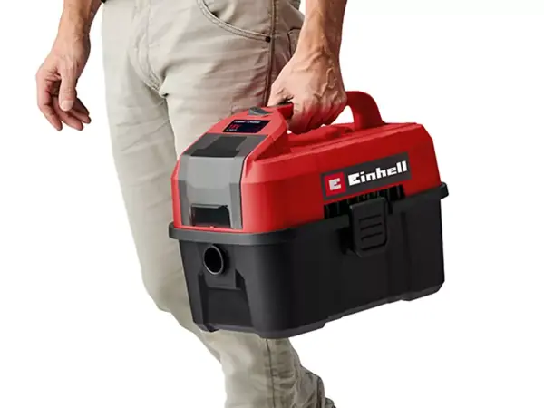 Eine Person trägt den handlichen Sauger am oberen Tragegriff.
