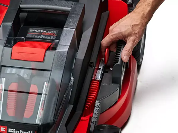 Eine Hand stellt die Schnitthöhe des Einhell Akku-Rasenmähers GE-CM 43 Li M Kit (2x4,0Ah) über den zentralen Hebel ein.