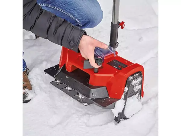 Osoba nastavuje směr odhozu sněhu přímo na zařízení.