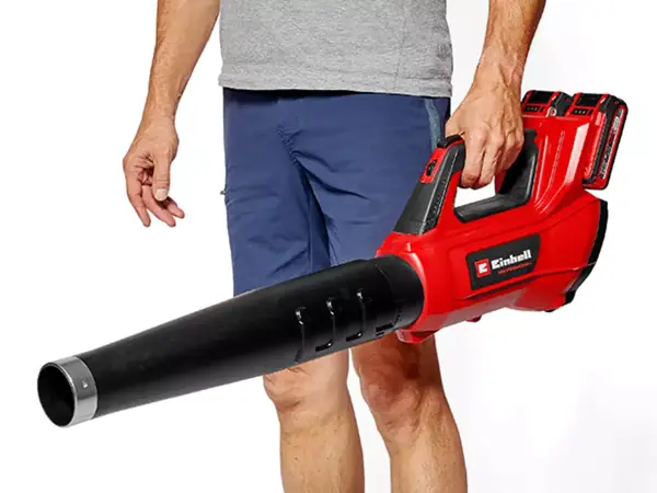 Muž drží akumulátorový foukač listí Einhell GP-LB 36/230 Li E BL-Solo za rukojeť v pravé ruce.