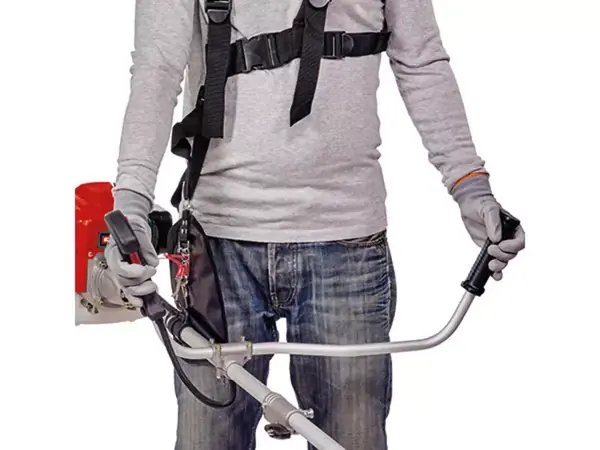 Benzínová kosa Einhell GC-BC 30/1 I AS s nastavitelnou dvouruční rukojetí při použití, nesená na těle.