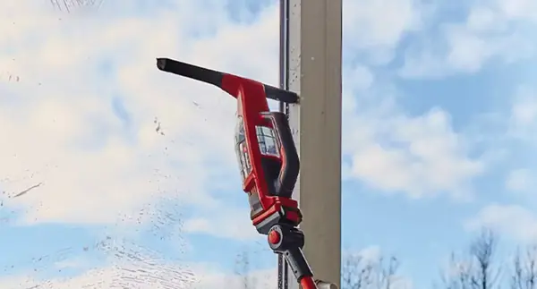 Aku čistič oken Einhell BRILLIANTO s nasazenou širokou hubicí ze sady trysek při práci na velké tabuli skla