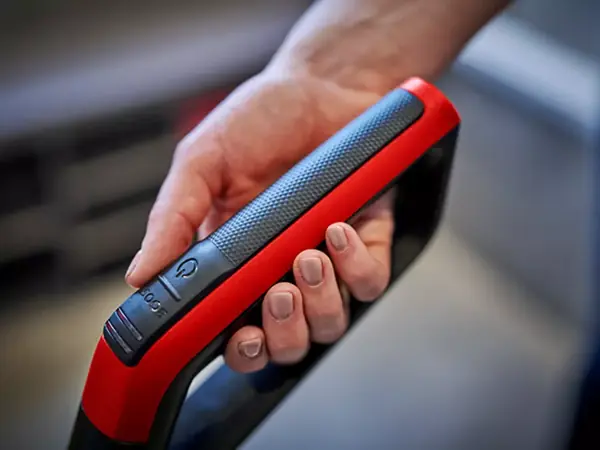Detailní záběr na ergonomickou rukojeť s měkkým úchopem akumulátorového čističe tvrdých podlah.