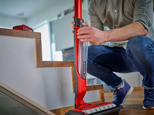 Osoba vyjímá nádrže na čistou a špinavou vodu z akumulátorového čističe tvrdých podlah Einhell.