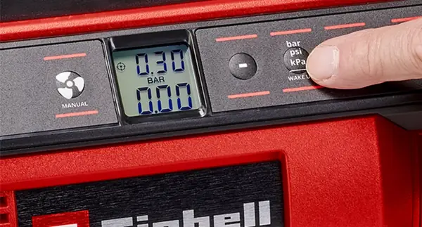 Detailní pohled na ovládací panel akumulátorového kompresoru Einhell PRESSITO 18/25 s displejem, ukazatelem tlaku v barech a tlačítky pro manuální ovládání a volbu jednotky tlaku (bar, psi, kPa).