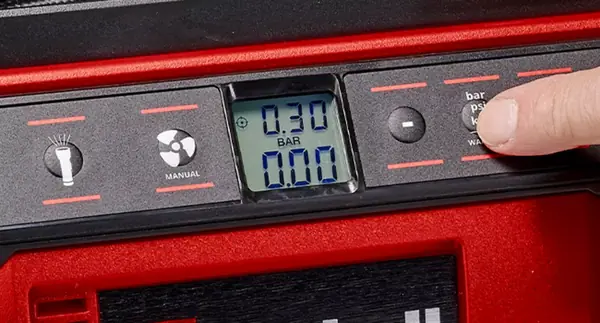 Ovládací panel akumulátorového kompresoru Einhell PRESSITO 18/25 Hybrid s LCD displejem, nastavením tlaku v barech, psi nebo kPa a tlačítky pro manuální nebo přednastavený režim.