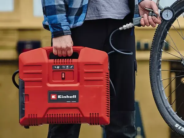 Der Kompressor wird wie ein Koffer getragen; gut sichtbar ist der Tragegriff an der Oberseite.