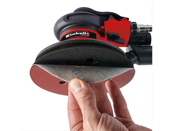 Ruka drží brusný papír, který je pomocí suchého zipu připevněn na brusném talíři Einhell TC-PE 150.