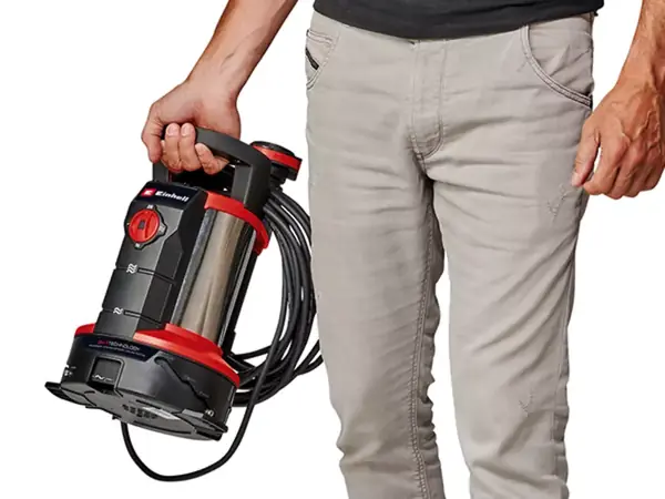 Osoba drží kalové čerpadlo Einhell GE-DP 7935 N-A LL ECO za madlo v jedné ruce, stojící vedle těla.