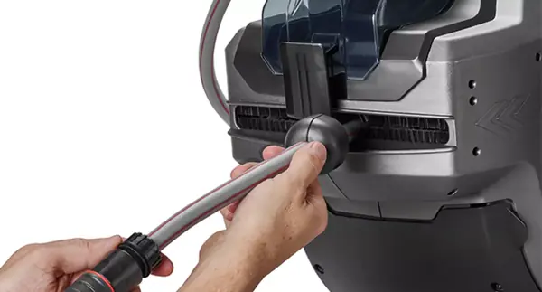 Ruka vytahuje hadici se zastavovací koulí z bezdrátového hadicového navijáku Einhell GE-HR 18/30-1 Li.