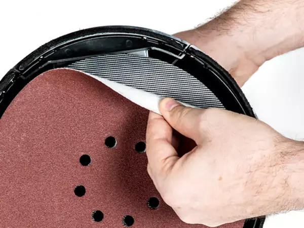 Detailaufnahme der Kletthaftung des Einhell Akku-Trockenbauschleifers TP-DWS 18/225 Li BL beim Anbringen einer Schleifscheibe.