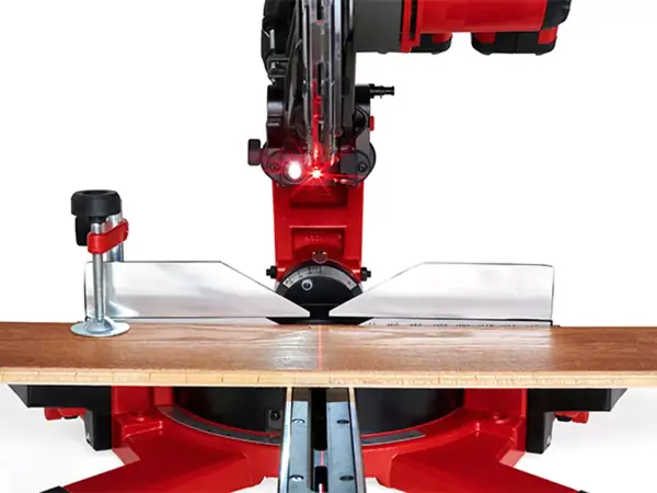 Pohled zepředu na bezkabelovou posuvnou pokosovou pilu Einhell TE-SM 36/10 L Li s aktivovaným laserem řezné čáry, který na obrobku označuje červenou čáru.