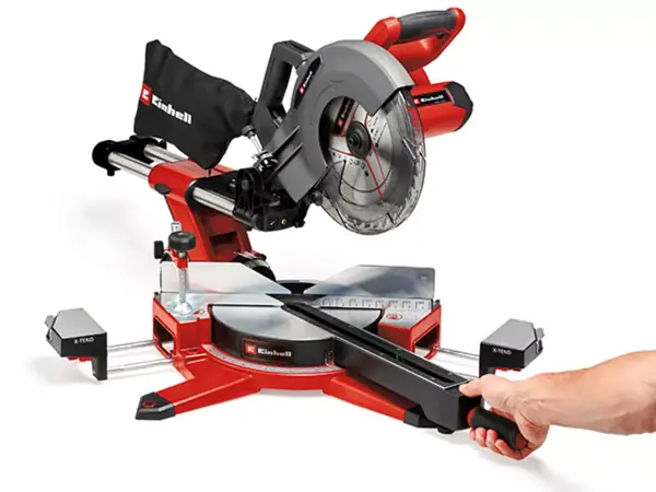 Ruka nastavuje otočný talíř bezkabelové posuvné pokosové pily Einhell TE-SM 36/10 L Li; jsou vidět pilový kotouč a stupnice úhlů.