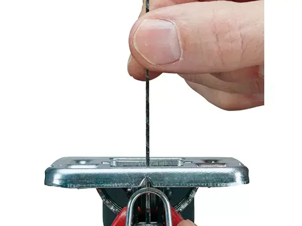 Ruka ukazuje výměnu pilového listu bez použití nářadí u přímočaré pily Einhell TC-JS 80/1.