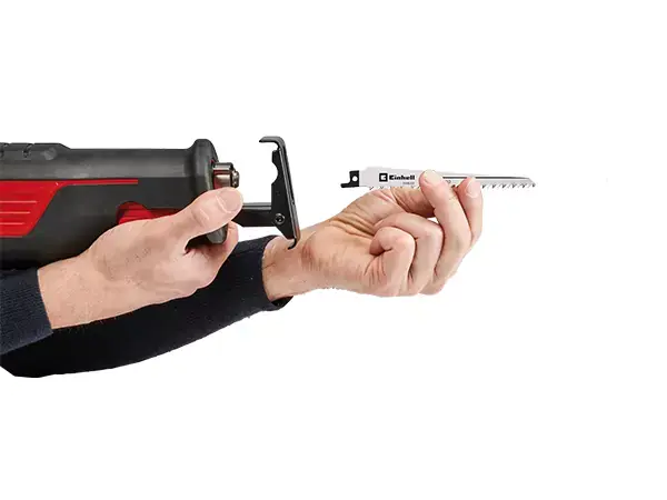 Beznástrojová výměna pilového listu na univerzální pile Einhell TE-AP 750 E znázorněná rukou.