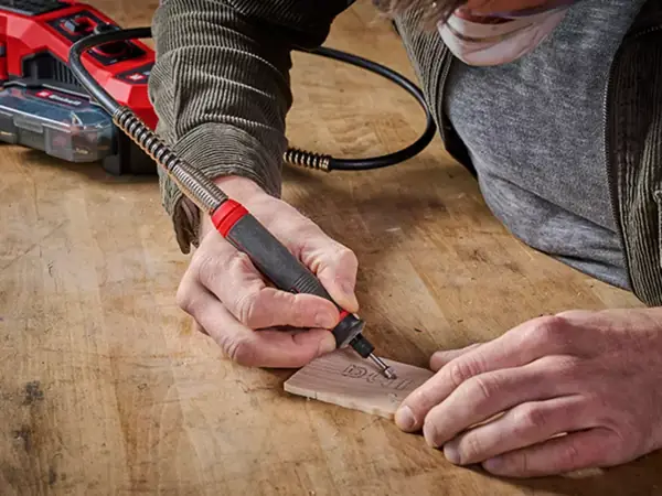 Akumulátorový brusný a gravírovací nástroj Einhell TE-MT 18/34 Li při gravírování na dřevěný povrch.