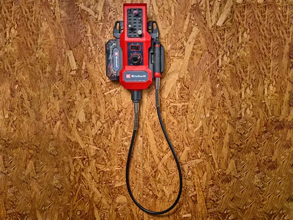 Akumulátorový brusný a gravírovací nástroj Einhell TE-MT 18/34 Li zavěšený na nástěnném držáku.