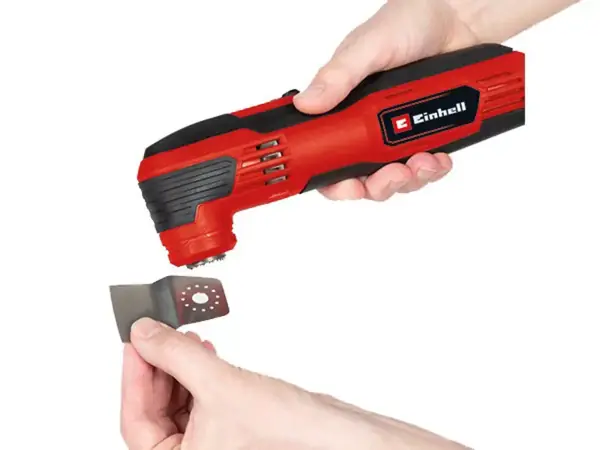 Eine Hand wechselt das Zubehör am Einhell Multifunktionswerkzeug TC-MG 250 CE mit Schraubverschluss.