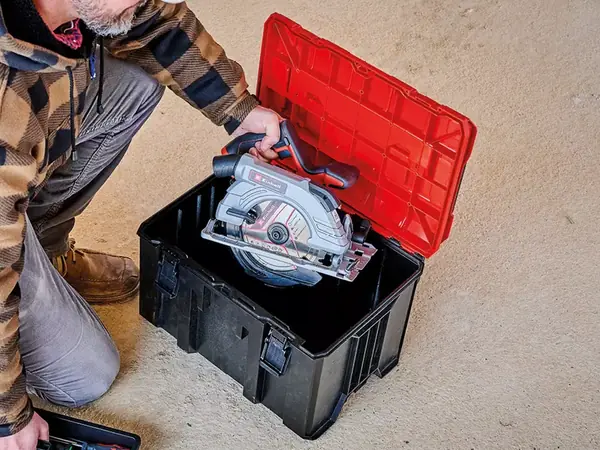 Osoba používá systémový kufr Einhell E-Case M pro uložení nářadí a příslušenství.