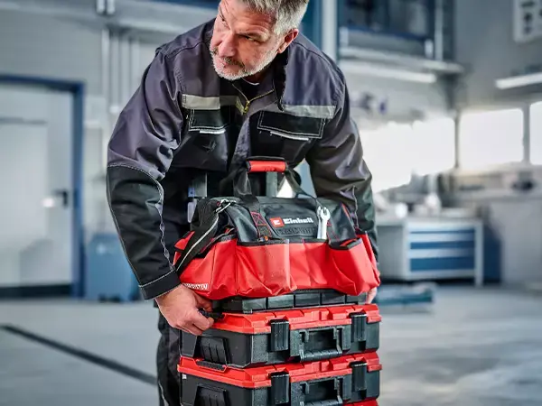 Osoba nese tašku Einhell E-Case za horní rukojeť.