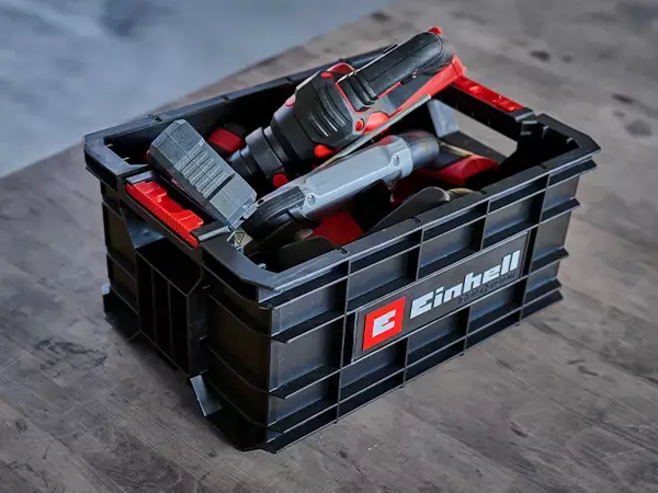 Nářaďový kufr Einhell E-Case naplněný nářadím stojí na dílenské podlaze.