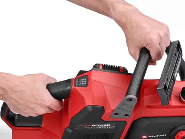 Dvě ruce drží aku řetězovou pilu Einhell GP-LC 36/40 Li BL-Solo za měkčené rukojeti na bílém pozadí.